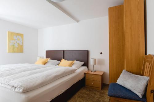 NiedersalweyFerienhaus Panoramablick的一间卧室配有一张大床和一把椅子