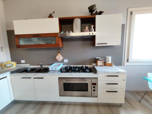 维琴察Bertesina325的厨房配有白色橱柜和炉灶烤箱。