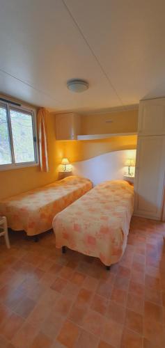 TautavelRESIDENCE TORRE DEL FAR的酒店客房带两张床和两个窗户