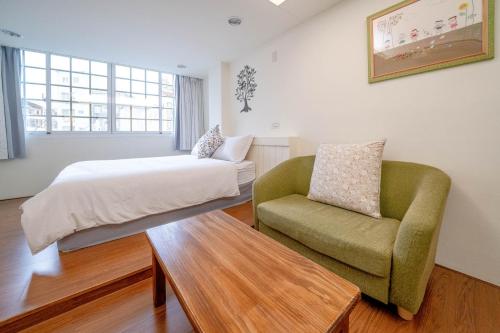 台南台南树夏民宿的一间卧室配有一张床和一把椅子