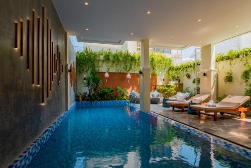 会安Hoi An Merrily De Art Hotel的一座带庭院的别墅内的游泳池