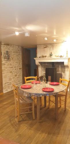 HumesChez Émile logement entier 2 chambres jardin privé的一间用餐室,配有红色盘子的桌子