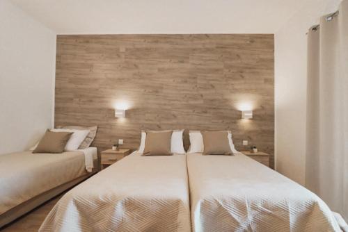 沃迪切俄里翁酒店的一间卧室设有两张床和砖墙