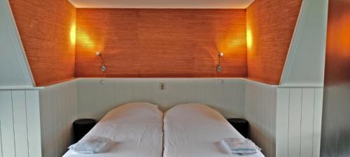 瓦门赫伊曾Hotelhuisje Warmenhuizen #A的一张位于房间的床,上面有两个枕头