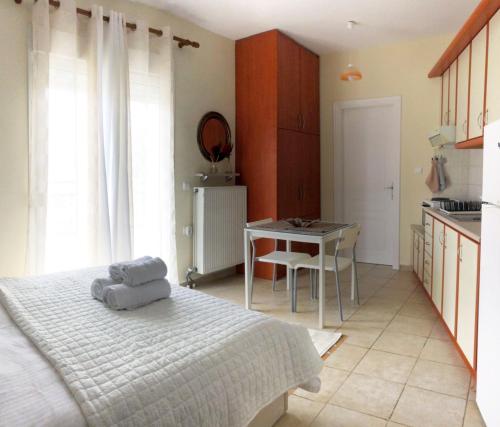 科扎尼Stergios_Apartments 05的一间卧室配有一张床铺和一张桌子,还设有一间厨房