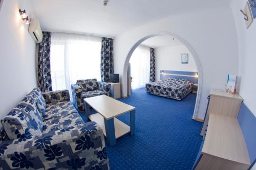 阳光海滩Palace Hotel - Half Board的酒店客房设有一张沙发和一张床