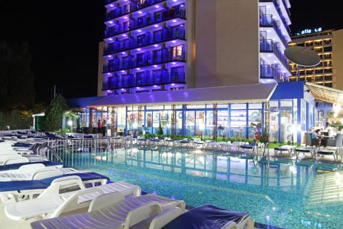 阳光海滩Palace Hotel - Half Board的一座带椅子的酒店游泳池以及一座夜间建筑