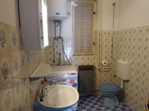 奥米沙利Apartment in Omisalj - Insel Krk 39736的一间带水槽和蓝色卫生间的浴室