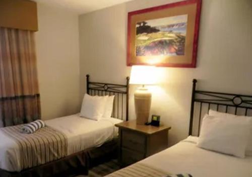 棕榈泉Vista Mirage Resort的酒店客房,设有两张床和一盏灯