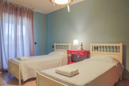 波吉邦西Apartment in Poggibonsi/Toskana 38410的一间设有两张床和一张红色桌子的房间