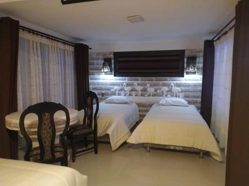 乌尤尼Hotel Kachi de Uyuni的酒店客房,配有两张床和两把椅子