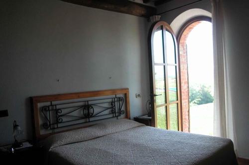 塞尔·迪·拉波拉诺Apartments in Asciano/Toskana 24096的一间卧室设有一张床和一个大窗户