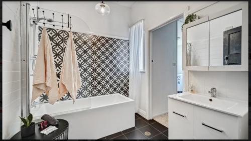 滕特菲尔德“唐纳利之家”度假屋的白色的浴室设有浴缸和水槽。