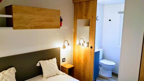 圣西普里安Mobile home De Luxe St Cyprien的一间小卧室,配有一张床和一个卫生间