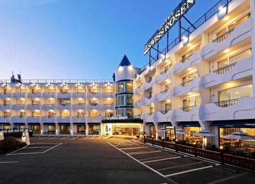 庆州贝尼凯瑞士罗森酒店的一座大型白色建筑,设有停车场