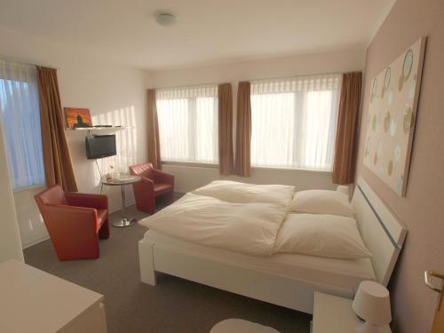 朗格奥Pension Friedrich Voss的卧室配有白色的床和2把椅子