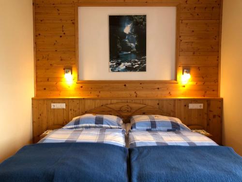 斯拉德明Ferienwohnung Staltner的一间卧室配有两张床,墙上有两盏灯