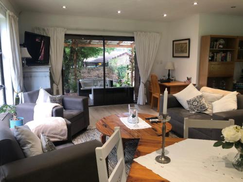 约翰内斯堡Waybury Cottage - a cozy home from home !的带沙发和桌子的客厅