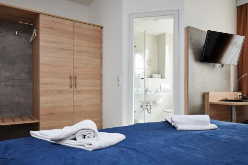 慕尼黑祖尔阿拉哈穆勒酒店的一间卧室配有蓝色的床和毛巾