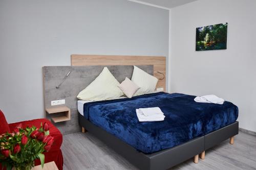 慕尼黑祖尔阿拉哈穆勒酒店的一间卧室配有一张床和一张红色椅子