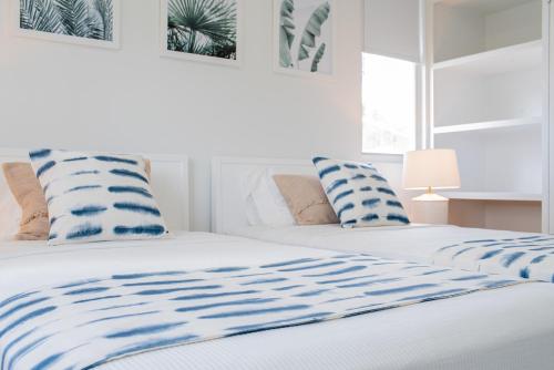 圣詹姆斯Garden Grove的一间卧室配有两张带蓝白色枕头的床