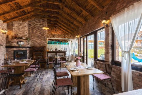 拉科维察Villa Waterfalls Plitvice的餐厅设有木桌、椅子和窗户。