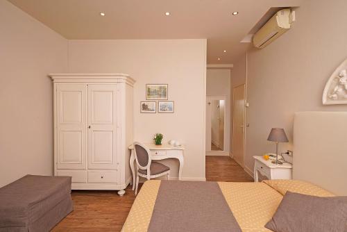 西尔米奥奈马可尼酒店的一间卧室配有书桌、一张床和一张桌子