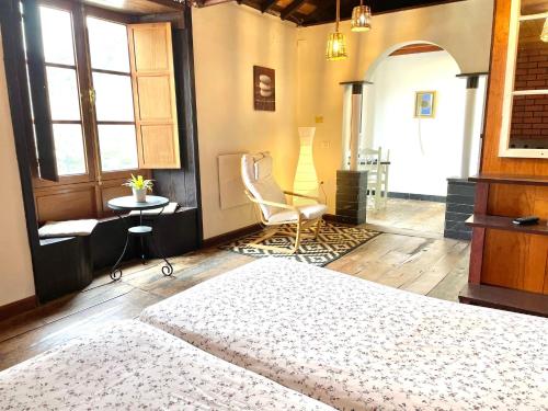 埃尔米瓜Casa El Patio的一间卧室配有一张床、一把椅子和一张桌子