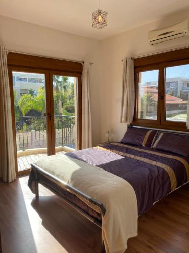 利马索尔EPISKOPI VILLA, Luxury 4 Bedroom with Pool - Limassol的一间卧室设有一张床和一个大窗户