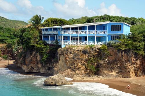 Sabana Westpunt蓝景公寓的海边悬崖上的蓝色房子