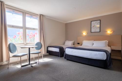 坎贝尔敦马克林汽车旅馆的酒店客房带两张床和一张桌子以及椅子。