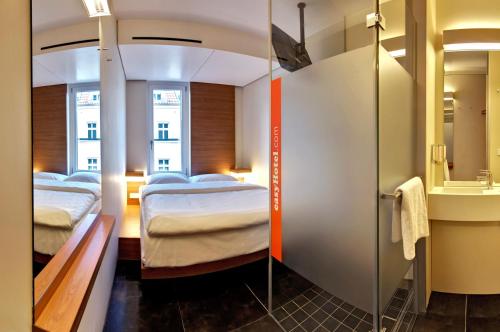 柏林柏林哈克市场便捷酒店的酒店客房,设有两张床和镜子