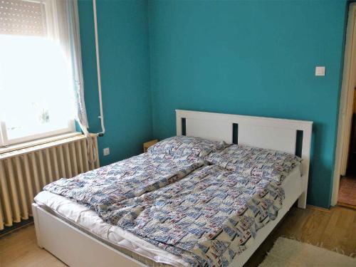 鲍洛通费尼韦什Holiday home in Balatonfenyves 18432的一间卧室配有一张蓝色墙壁的床