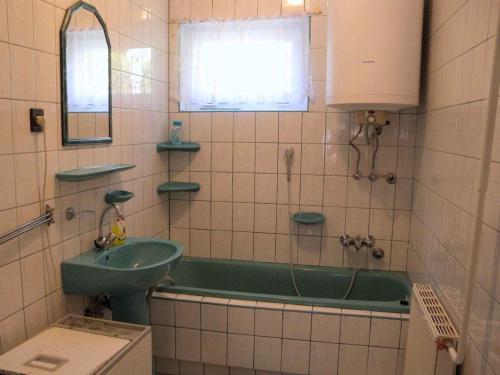 鲍洛通费尼韦什Apartment Balatonfenyves/Balaton 18403的浴室配有绿色浴缸和水槽