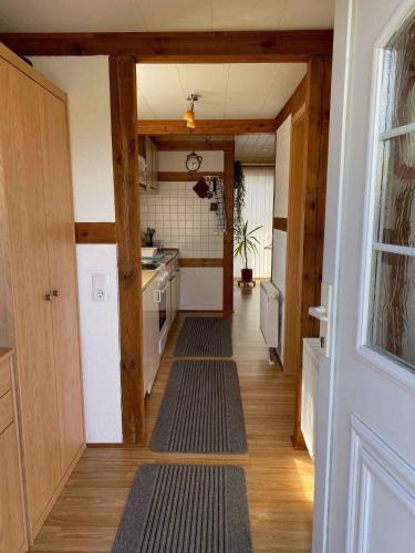 GustowHoliday home in Gustow/Insel Rügen 3077的走廊通往铺有木地板的厨房
