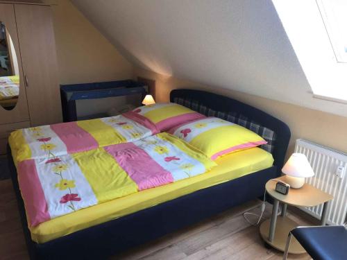 HaidhofApartment Gingst 1的一间卧室配有一张黄色和粉色毯子的床