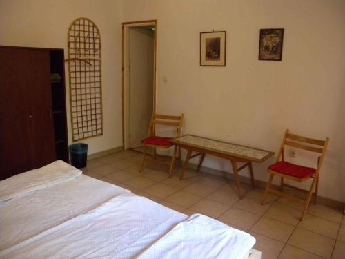 鲍洛通费尼韦什Holiday home in Balatonfenyves 18357的卧室配有两把椅子、一张桌子和一张床
