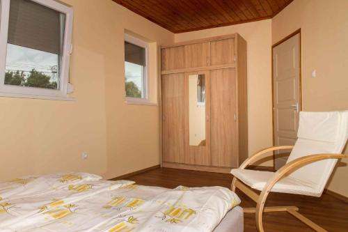 鲍洛通凯赖斯图尔Holiday home Balatonkeresztur 24的卧室配有床、椅子和窗户。
