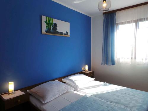 ValbandonApartment in Valbandon/Istrien 11260的一间卧室设有蓝色的墙壁和一张床