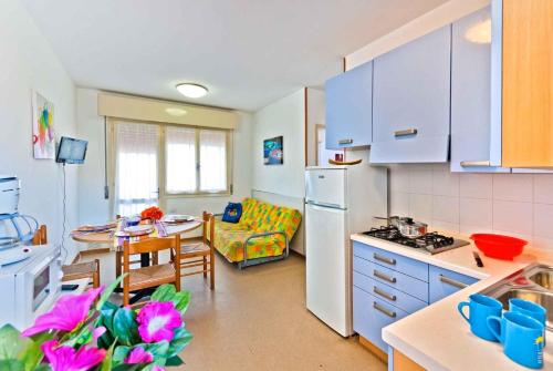 比比翁Apartments in Bibione 25584的设有带蓝色橱柜和桌子的厨房以及带用餐室的厨房。