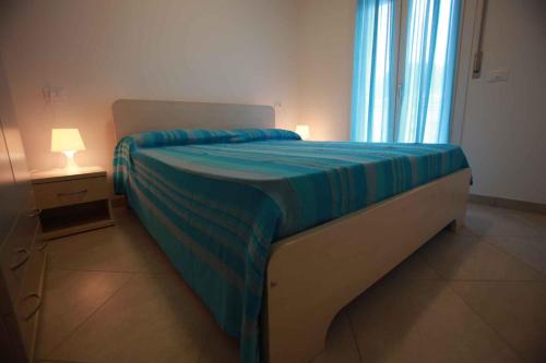 罗索利纳马雷Two-Bedroom Apartment Rosolina Mare near Sea 3的一间卧室配有一张带蓝色毯子的床