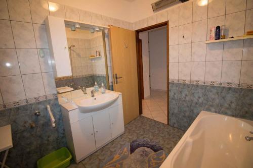 坎普尔Apartment Kampor 1的浴室配有盥洗盆、镜子和浴缸