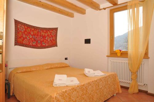 莱德罗Holiday home in Pieve di Ledro 22670的窗户和床罩的房间里一张床位