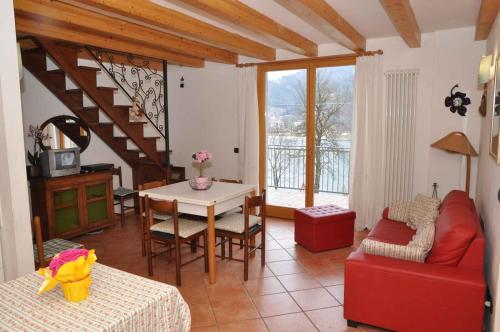 莱德罗Holiday home in Pieve di Ledro 22670的客厅配有红色的沙发和桌子