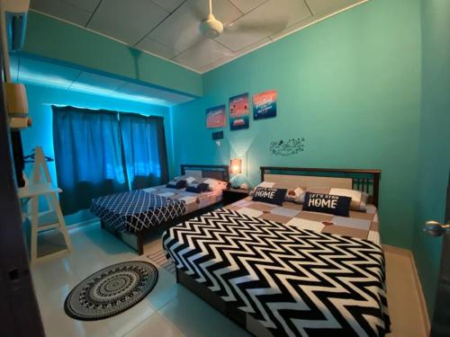 仙本那Suhana HomeStay Semporna - Cozy Home的蓝色墙壁客房的两张床