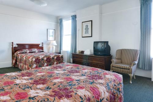 旧金山艾达广场酒店的酒店客房带一张床、一台电视和一把椅子