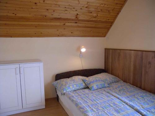 鲍洛通凯赖斯图尔Holiday home in Balatonmariafürdo 33086的一间卧室设有一张床和木制天花板