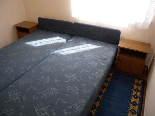 鲍洛通费尼韦什Apartment Balatonfenyves/Balaton 18390的一张位于带一张桌子的蓝色床罩的房间里的床