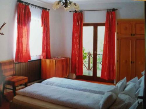 EbhegyApartment Balatonszarszo/Balaton 20085的一间卧室配有红色窗帘、一张床和窗户
