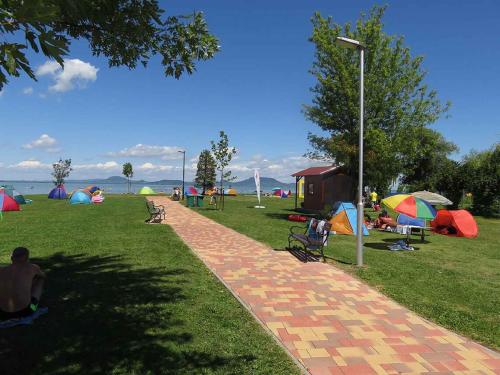 鲍洛通凯赖斯图尔Holiday Home Balatonmariafurdo, Somogy 1的公园里有帐篷,人们坐在草地上